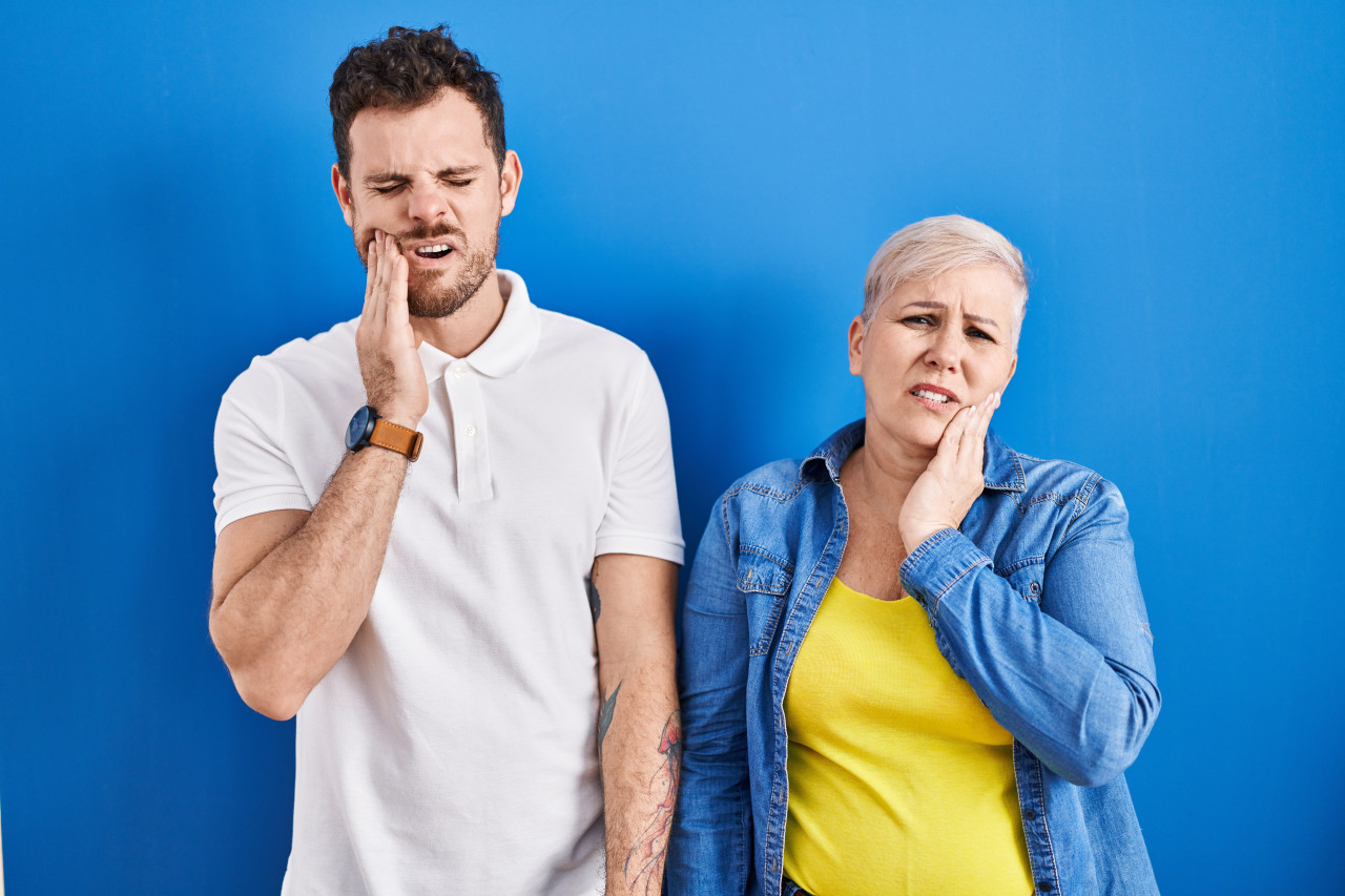 young-brazilian-mother-son-standing-blue-background-touching-mouth-with-hand-with-painful-expression-because-toothache-dental-illness-teeth-dentist
